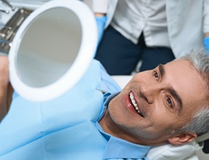 a patient checking his teeth with a mirror