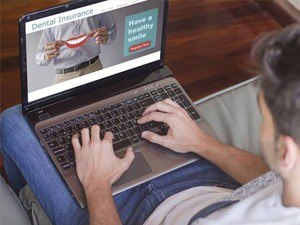 Man looking at dental insurance on laptop