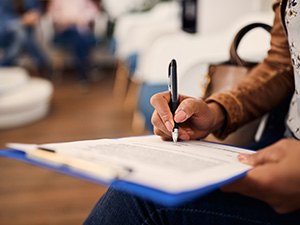 Woman filling out dental insurance form in lobby