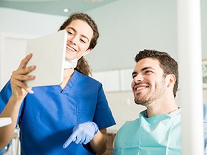 Dentist showing patient image on tablet